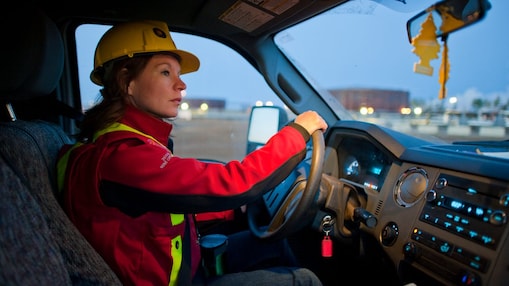 A lady wearing safety equipment driving a vehicle