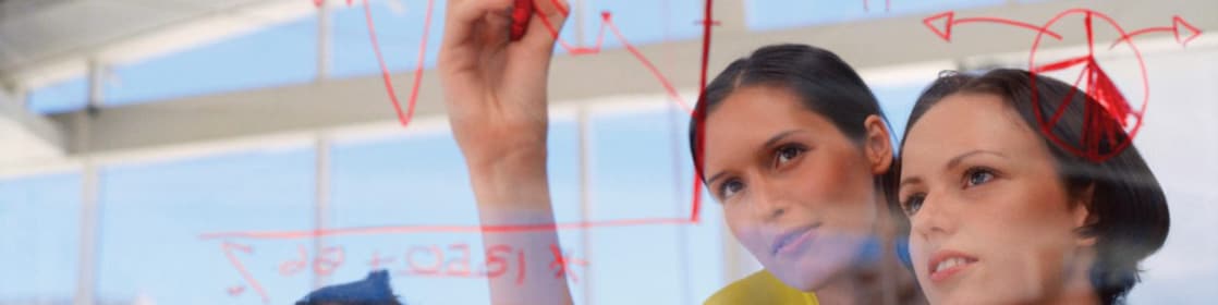 Businesswoman drawing graphs on glass